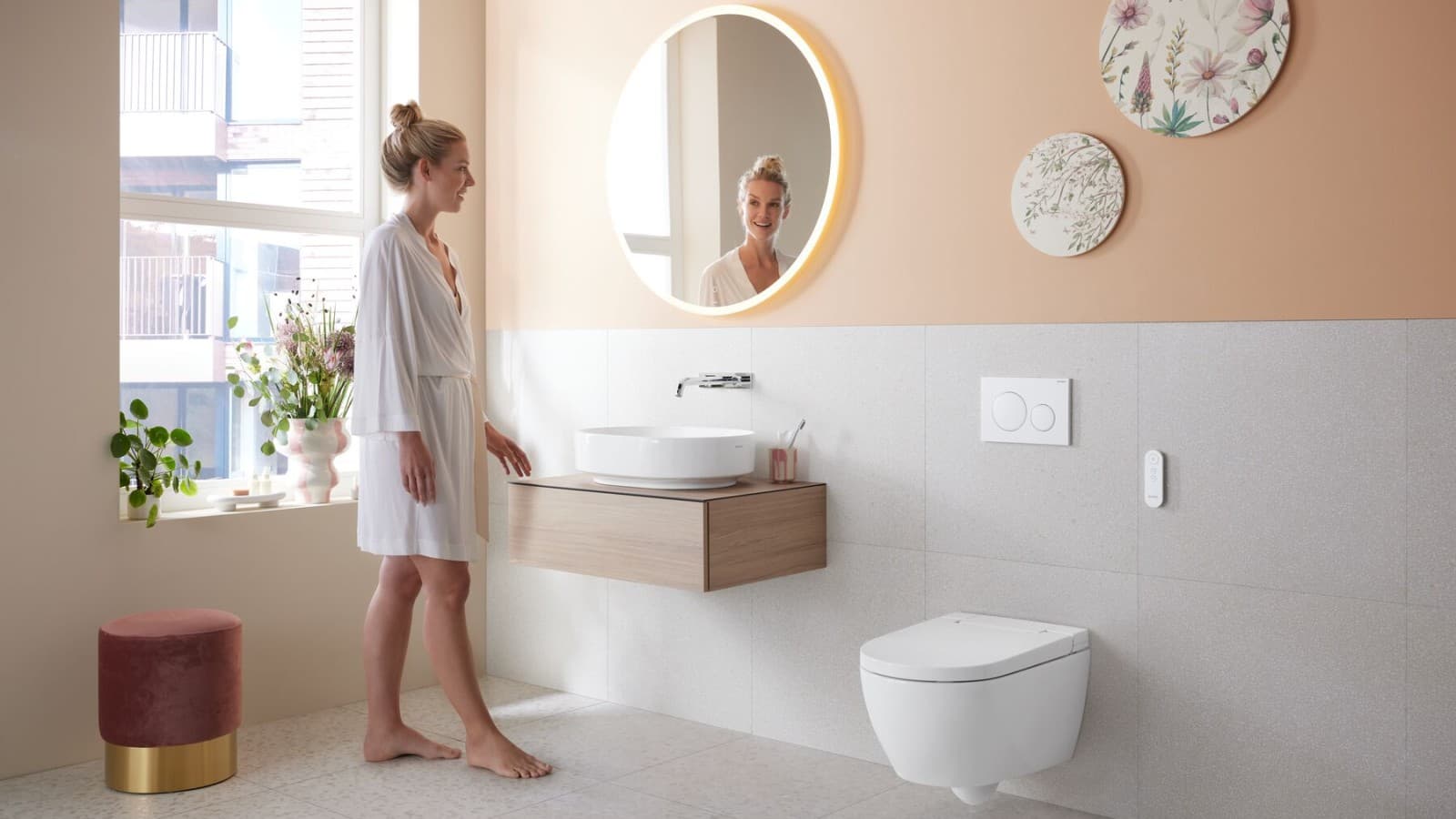 Femme dans la salle de bains avec Geberit AquaClean Alba Femme dans la salle de bains avec Geberit AquaClean Alba