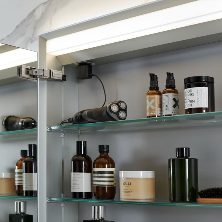 Geöffneter Geberit Spiegelschrank, in dem Badutensilien verstaut sind Geöffneter Geberit Spiegelschrank, in dem Badutensilien verstaut sind