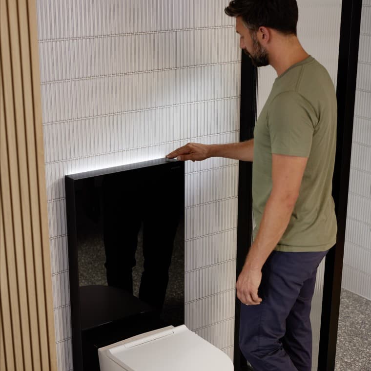 Mann neben Sanitärmodul Geberit Monolith Plus Mann neben Sanitärmodul Geberit Monolith Plus